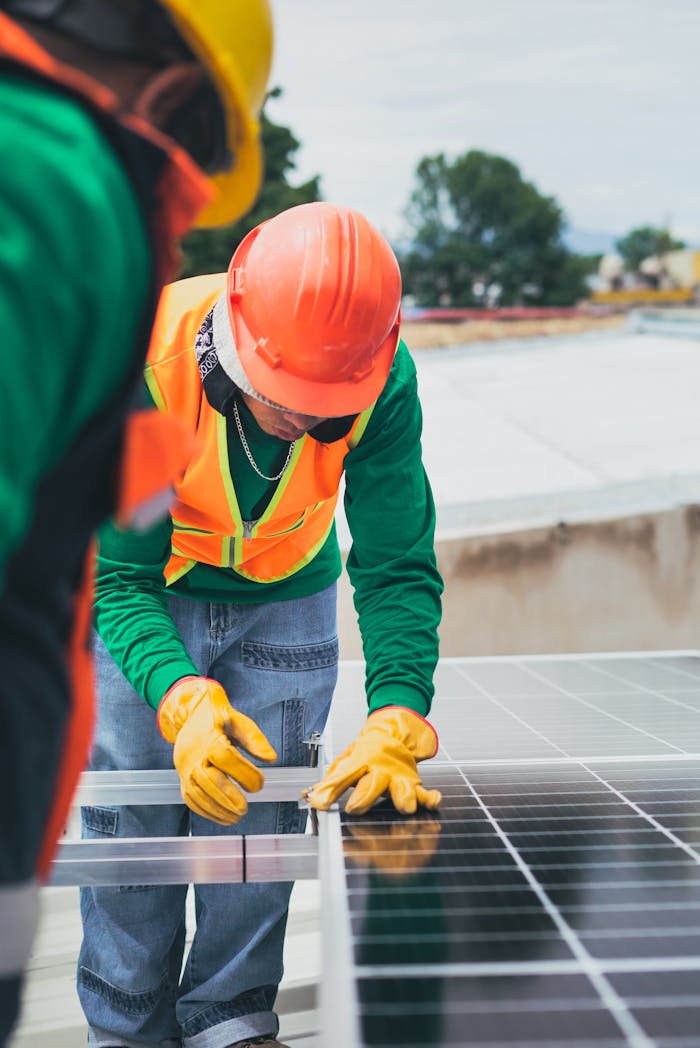 brand-03 Worker in safety gear installing solar panels on a rooftop.